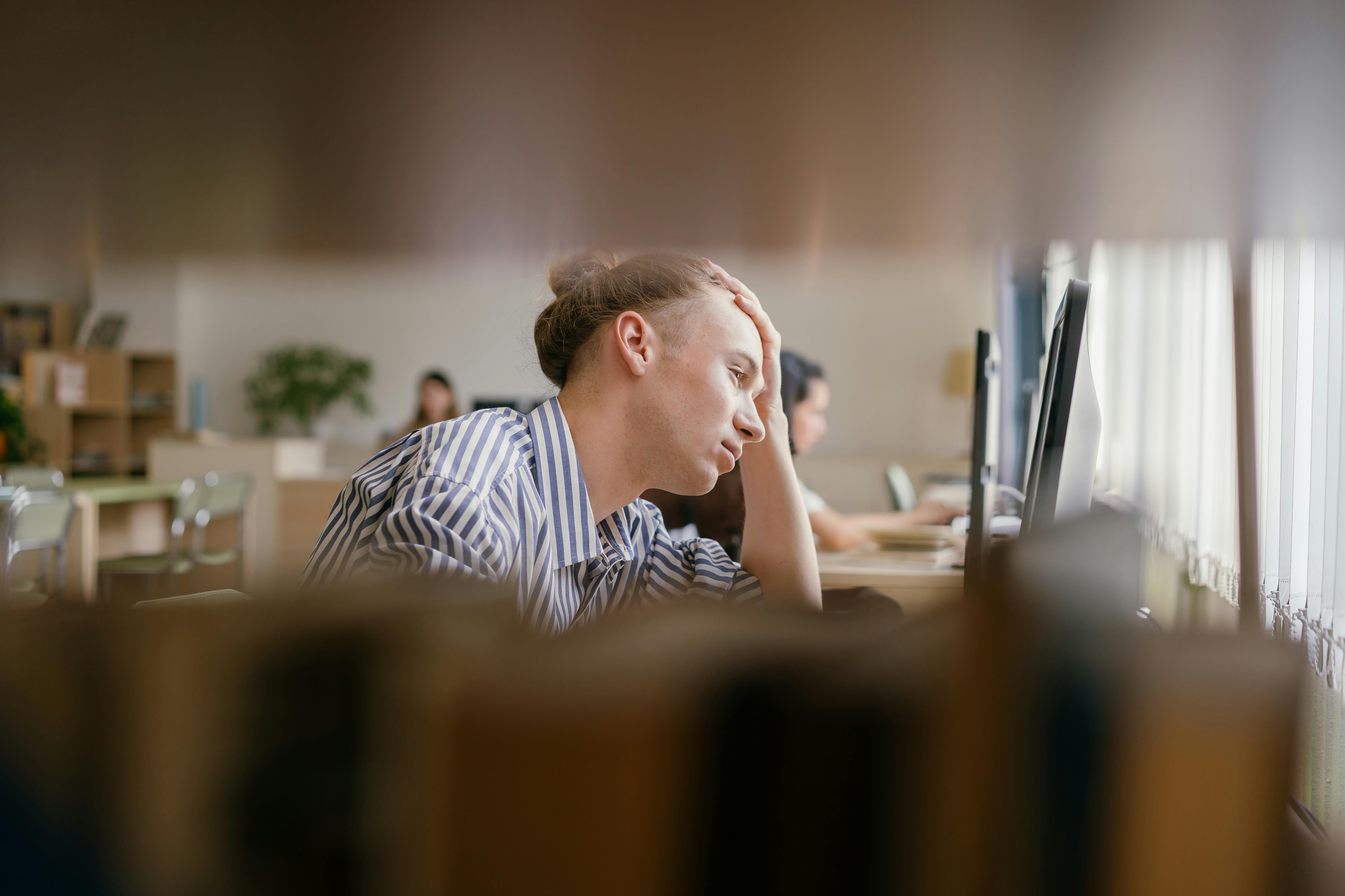 Stressed student looking at computer monitor