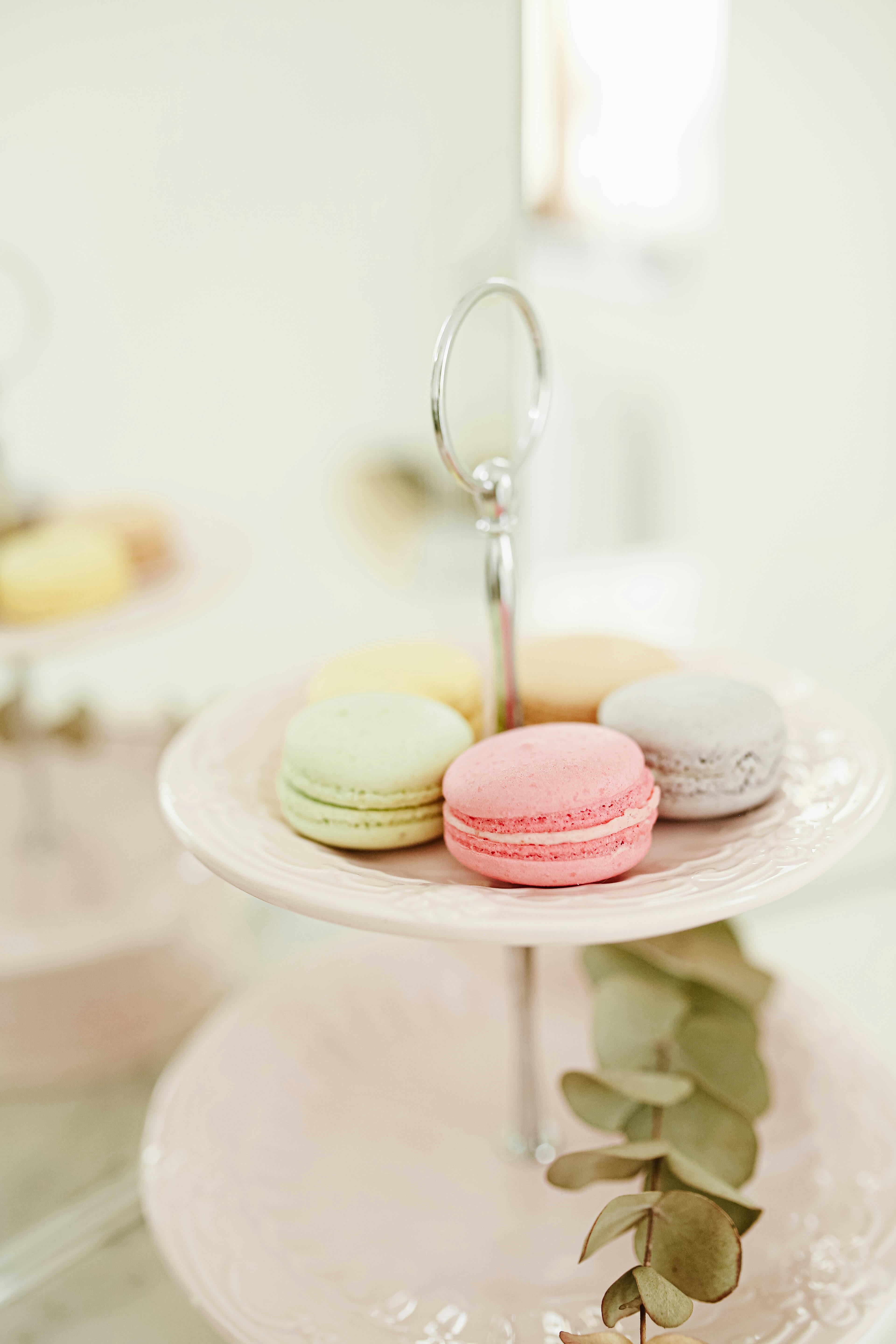 A pastel-colored assortment of macarons elegantly displayed on a two-tier stand, creating a delightful visual treat.