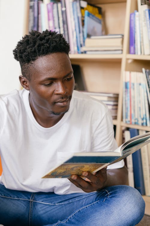 Free A Man in White Shirt Reading a Book Stock Photo