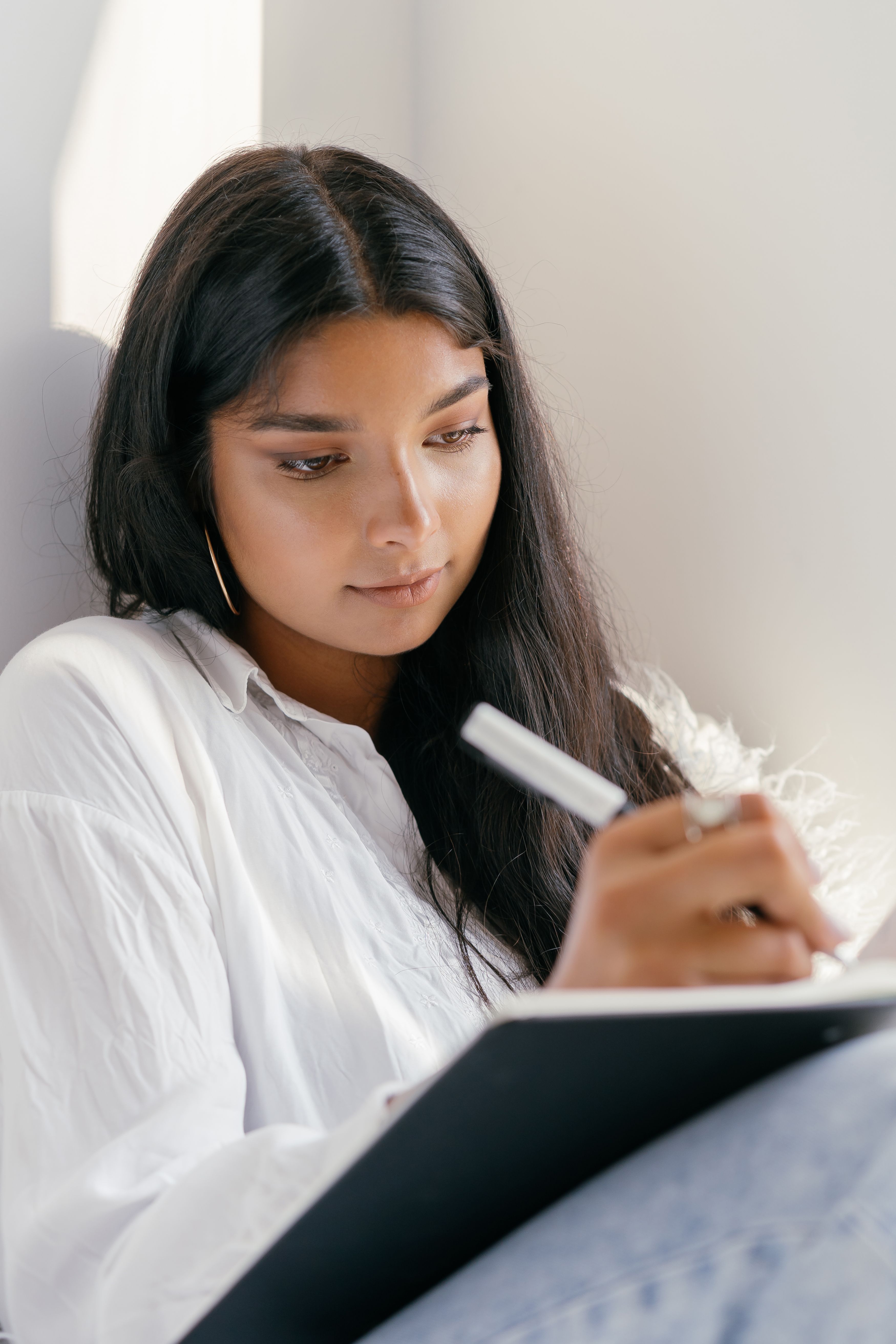 A Woman Holding a Pen and a Notebook · Free Stock Photo