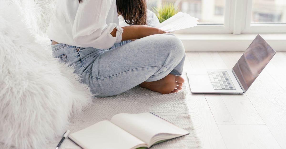 A student meditating with a laptop open nearby