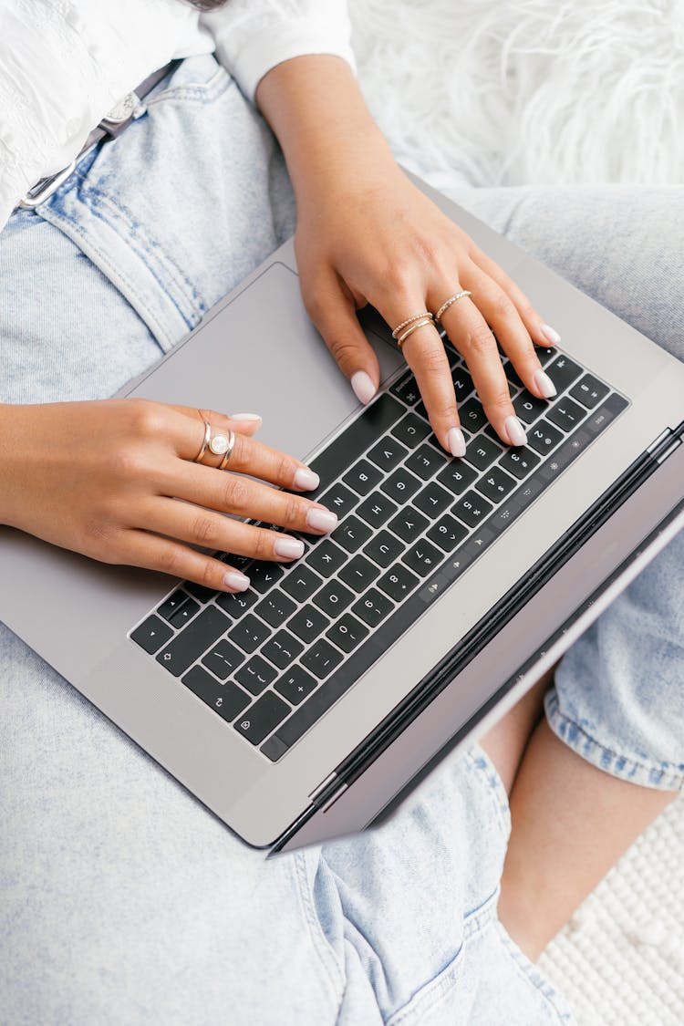 Overhead Shot Of A Person's Hands Typing On A Laptop Keyboard