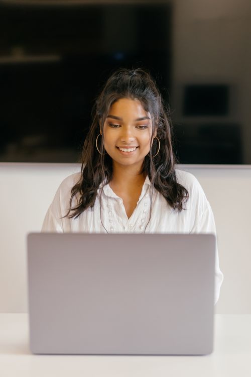 Free A teenager studying indoors with a laptop, showing focus and diligence. Stock Photo
