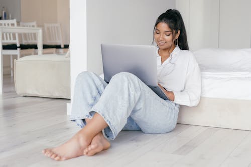Free Woman Sitting on the Floor While Using a Laptop Stock Photo