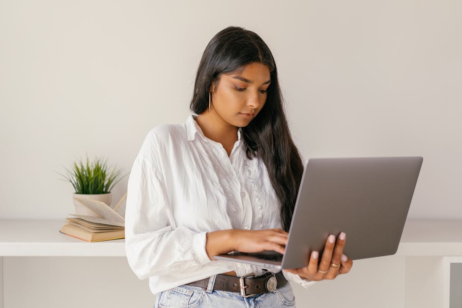 A Woman in White Dress Shirt Using a Laptop