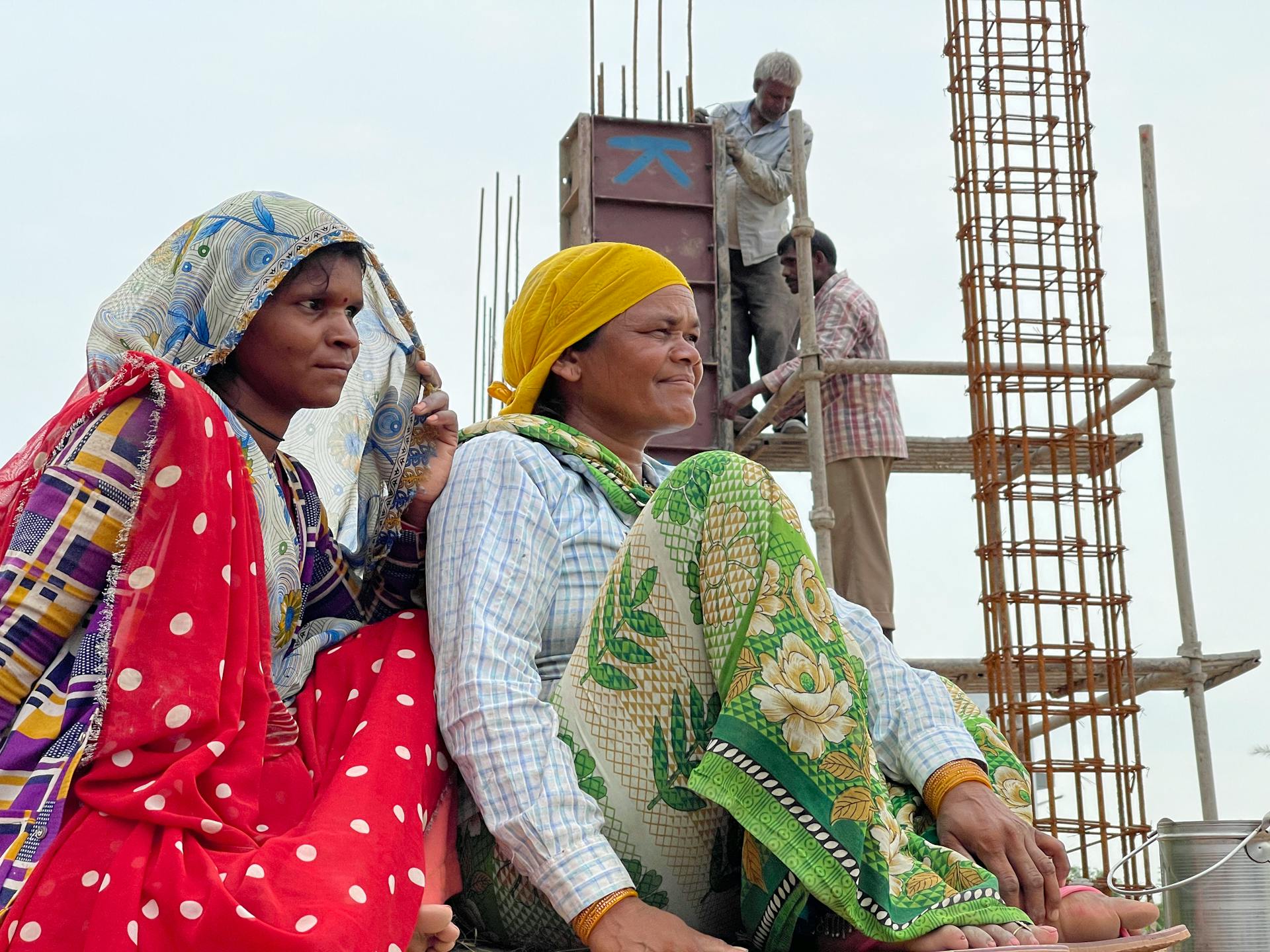 Indian construction workers at a site in Rasulpur, showcasing traditional attire and teamwork.