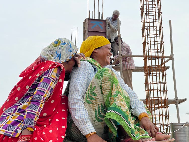 Old Women In Traditional Clothes Laughing At Construction Site