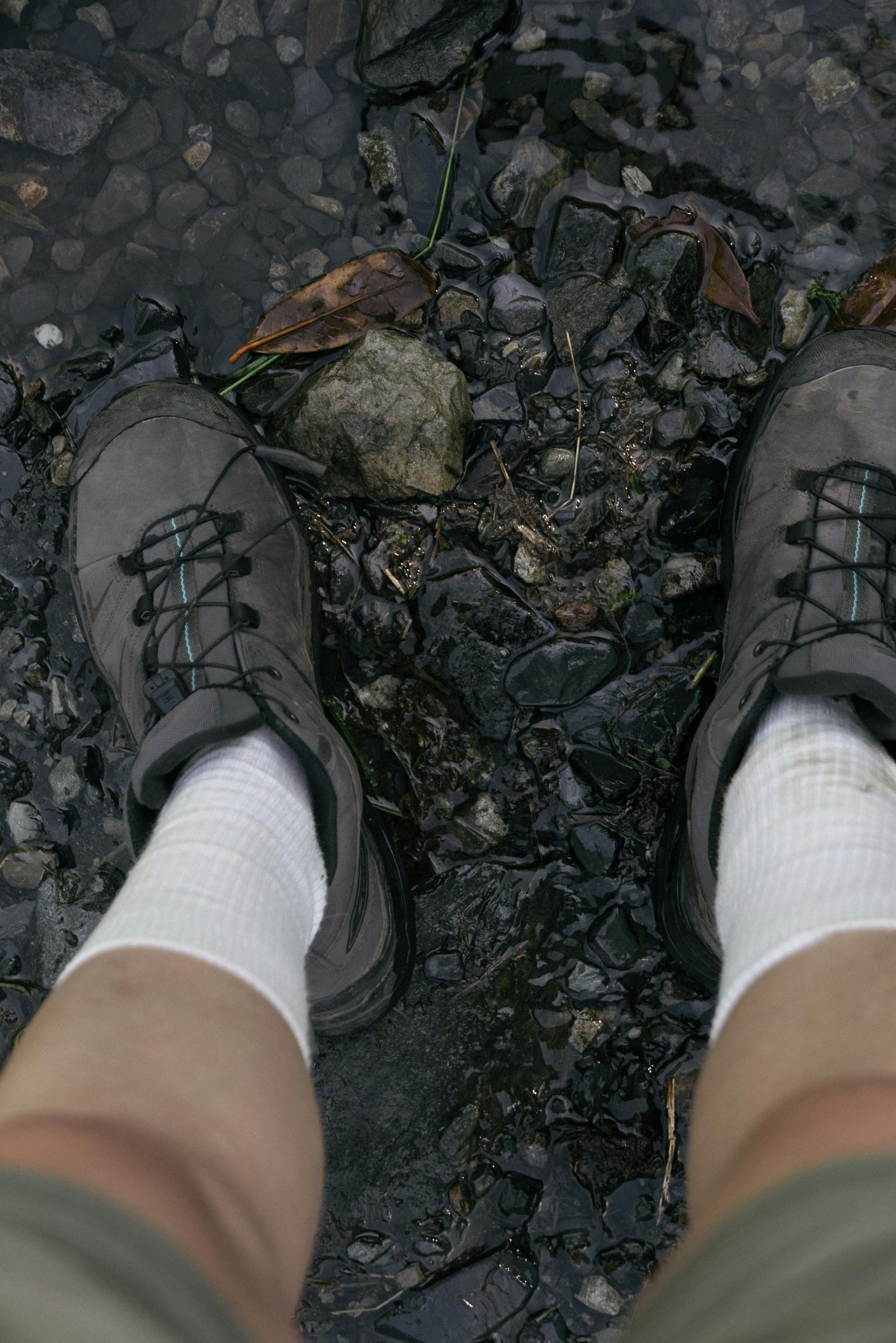 Top view of hiking boots on a rocky trail, perfect for outdoor adventure themes.