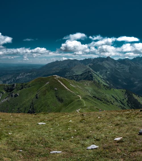 Free Explore a stunning mountain range with lush greenery and dramatic clouds, perfect for nature enthusiasts. Stock Photo