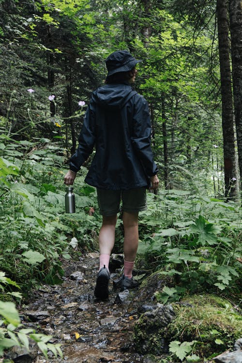 A Woman Wearing a Black jacket Walking in the Woods
