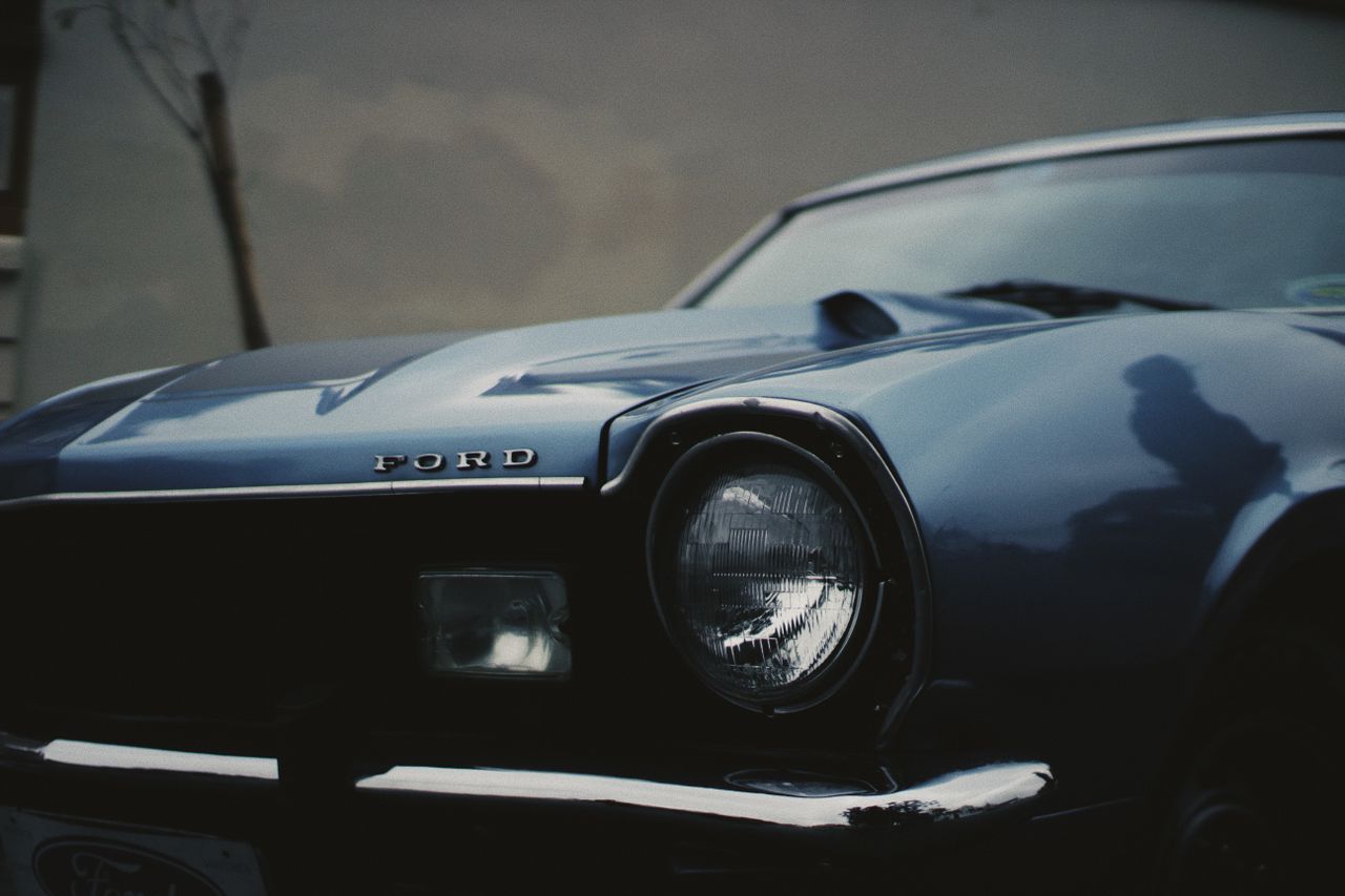 detailed close up of a vintage blue ford car s headlight showcasing cl