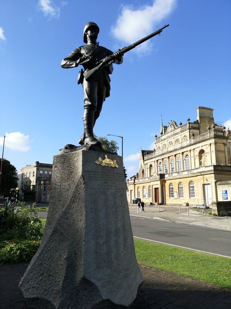 Man In Soldier Statue Near Beige Building