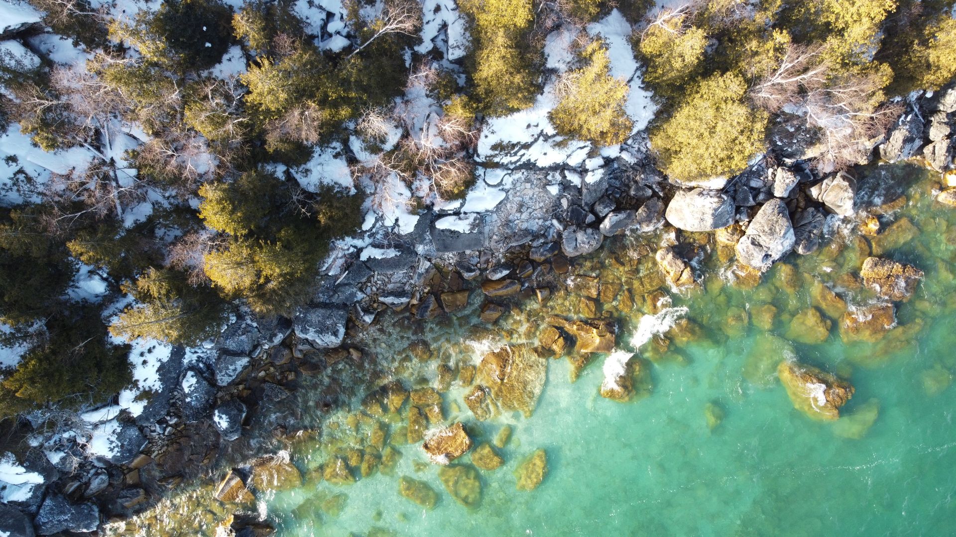 A stunning aerial view of the rocky and snowy shoreline of Miller Lake, Ontario.