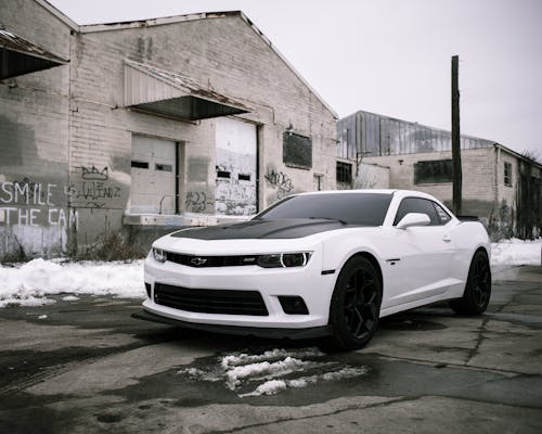 White Chevrolet Car Parked Near Brown Building