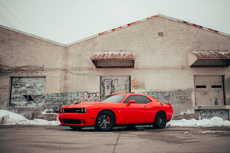 Red Car Parked Near Brown Building