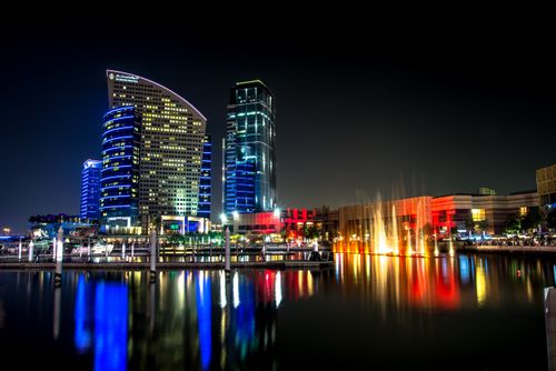Free Stunning night view of Dubai's illuminated architecture reflecting on the water. Stock Photo