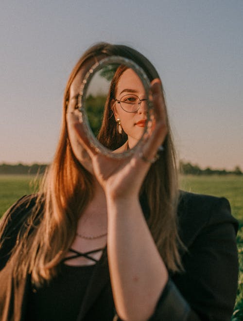 Free A Woman Holding a Mirror Stock Photo