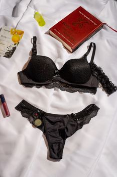 Black lace lingerie set beautifully displayed with books and accessories.