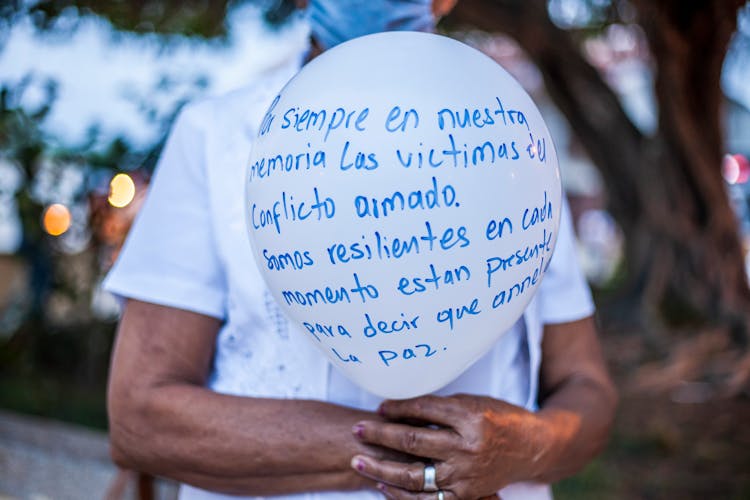 A Person Holding A White Balloon With Message