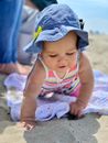 Cute Baby Girl Wearing Hat Crawling on Sand