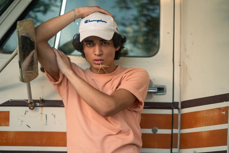 Man In Baseball Hat Near Vintage Car