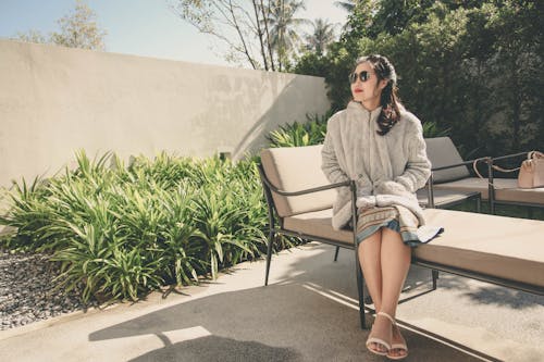 Woman Wearing Hoodie Sitting on Lounge Chair