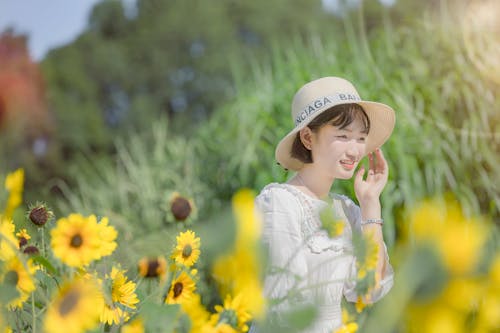 Young Woman in Sun Hat Among Yellow Flowers