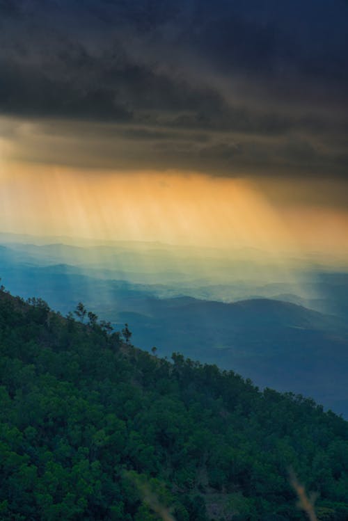 Free Rays Through the Clouds on Hills Stock Photo