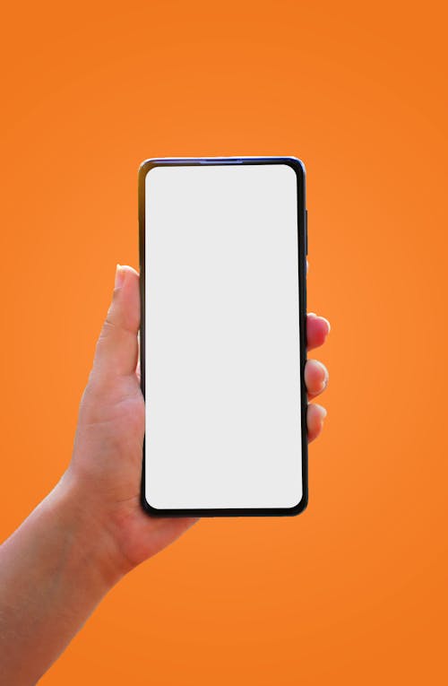 Free Person Holding Mobile Phone with Empty Screen  Stock Photo