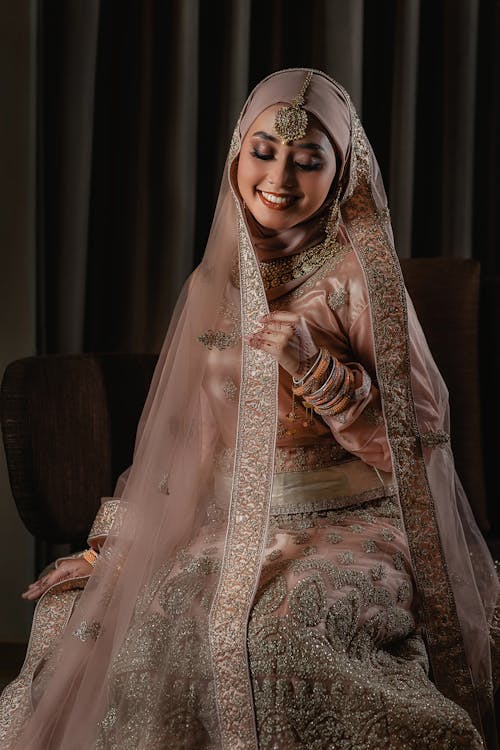 Smiling Woman in Beige Dress with Embroidery and Hijab