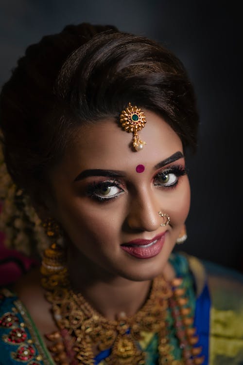 A Woman with Bindi Wearing Gold Head Accessory
