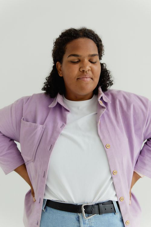 Free Portrait of a confident African American woman with eyes closed, wearing a pastel outfit in a studio setting. Stock Photo