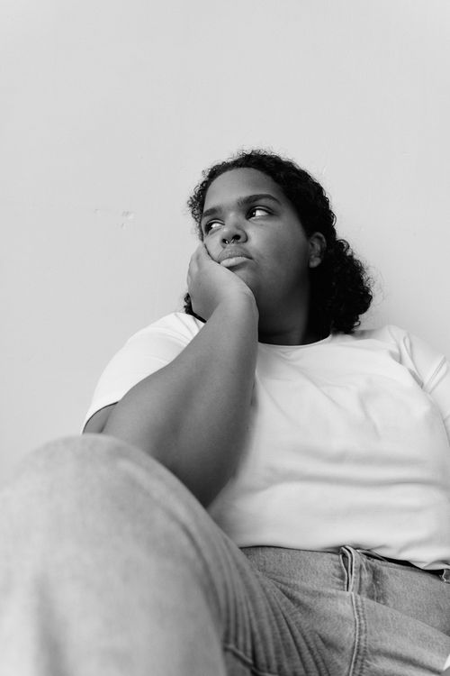 Free Black and white portrait of a woman in casual pose, evoking deep thought and introspection. Stock Photo