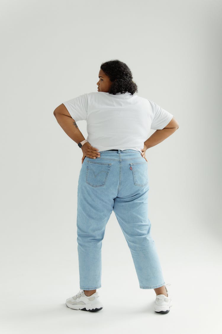 Back Of A Woman In White Shirt And Denim Pants