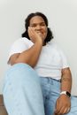 Woman in White Crew Neck T-shirt and Blue Denim Jeans Sitting on White Chair