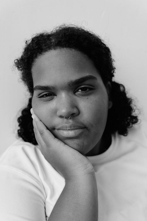 Free Black and white portrait of a woman resting her chin on her hand, exuding calmness. Stock Photo
