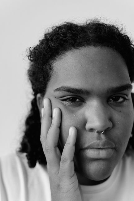 Emotive black and white portrait of a young woman with a contemplative expression, captured with Canon EOS 5D Mark IV.