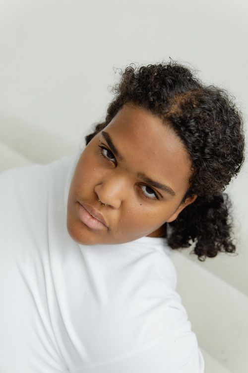 Free Close-up portrait of a plus-size woman with curly hair, exuding strength and confidence. Stock Photo