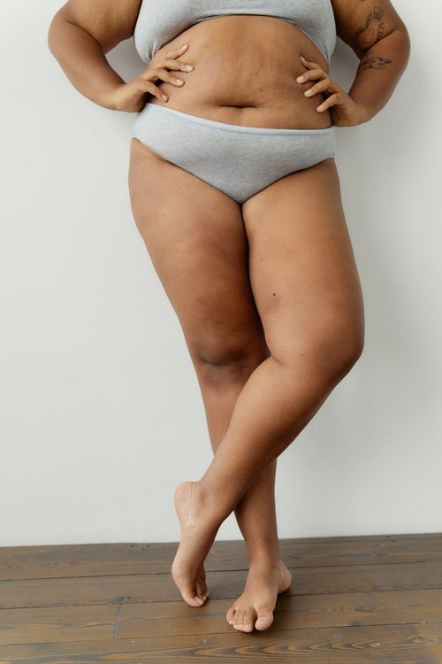 Free Empowering image of a plus-size woman standing confidently in underwear. Promotes body positivity and self-acceptance. Stock Photo