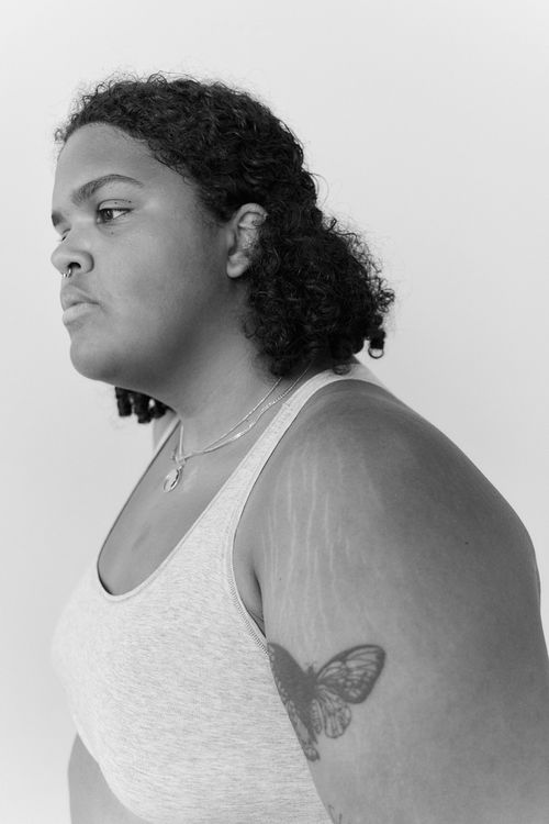 Free Side view portrait of a tattooed woman with curly hair in monochrome. Stock Photo