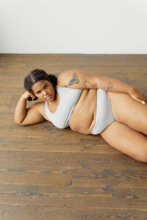 A Woman Lying Down on the Floor in Her Underwear