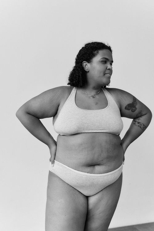 Free Black and white portrait of a confident plus size woman in lingerie posing indoors. Stock Photo