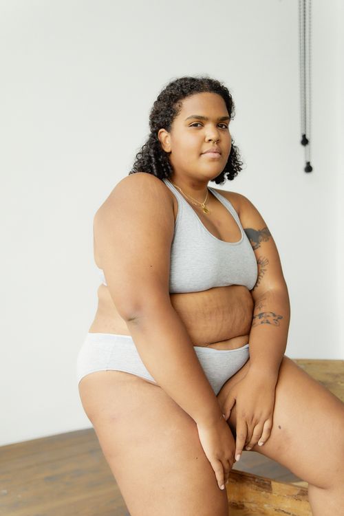 Free Empowering portrait of a plus size black woman in grey lingerie, promoting body positivity and self-confidence. Stock Photo
