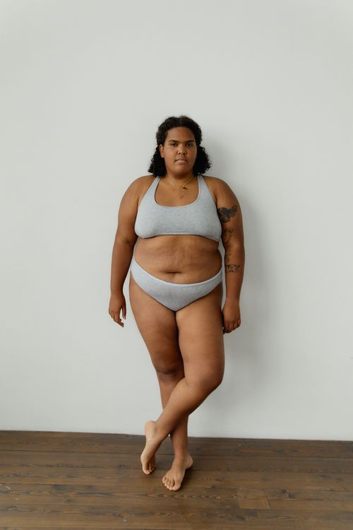 Free Portrait of a confident plus size woman embracing body positivity in gray underwear. Stock Photo