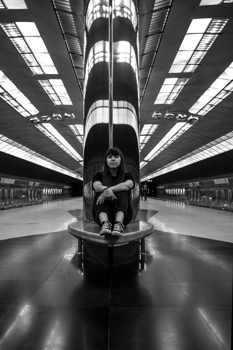 Woman Sitting On A Bench In A Subway Station