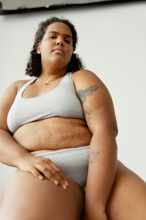 Free Confident plus-size woman in lingerie showcasing body positivity from a low angle. Stock Photo