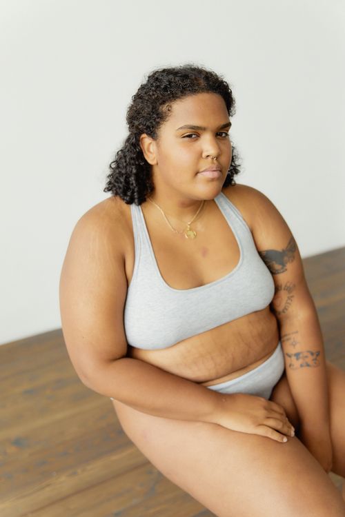 Free Confident plus size woman in lingerie showcases body positivity and empowerment indoors. Stock Photo