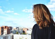 晴朗的一天，一名女子站在屋顶上，凝望着圣彼得堡的城市天际线