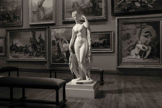Grayscale image of a classic sculpture in a French art gallery, emphasizing artistry.