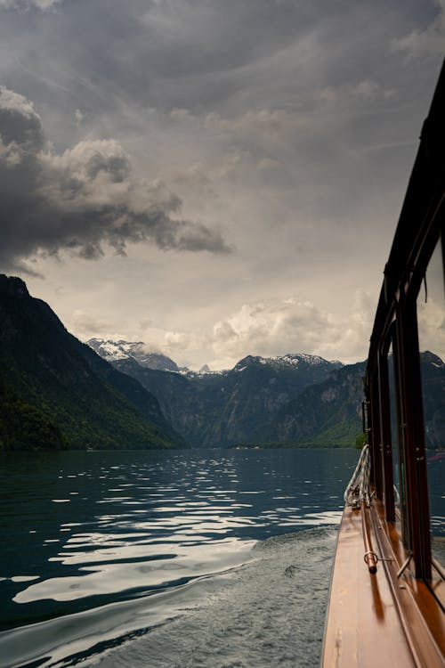 Free Ferry Boat on a Lake near Rocky Mountains under Cloudy Sky  Stock Photo